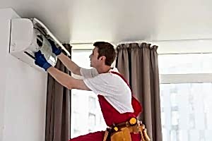 Service man is cleaning, repair and maintenance of air conditioner.